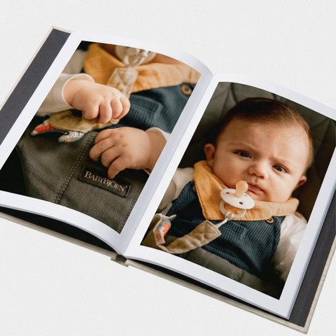 Open hardcover photo book with fabric cover showing a full-bleed portrait spread